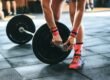 person locking gym plates on barbell